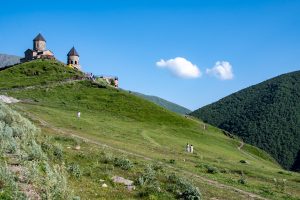 De Gergeti-drievuldigheidskerk op een groene heuvel bij Stepantsminda in Georgië