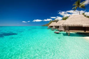 Huisjes met rieten daken op palen boven een turquoise lagune